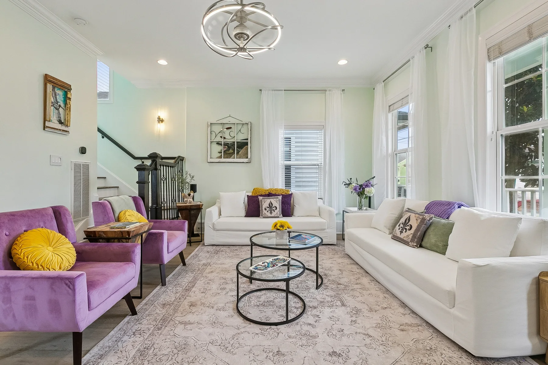 Purple chairs, gold cushions and white sofas in the furnished St. Ferdinand living room